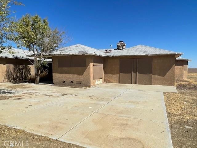 view of front of home featuring crawl space, stucco siding, a chimney, and a patio