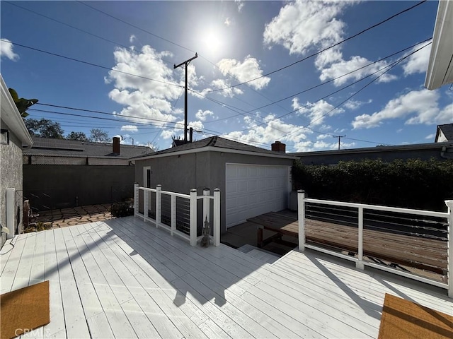 wooden terrace featuring an outbuilding and a detached garage