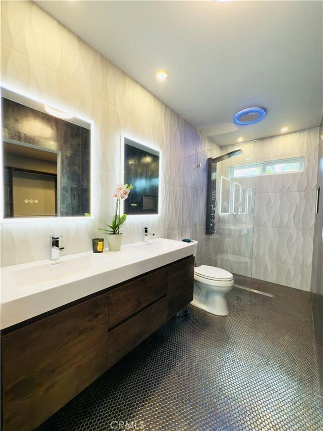 bathroom featuring toilet, a sink, tile walls, tile patterned floors, and walk in shower