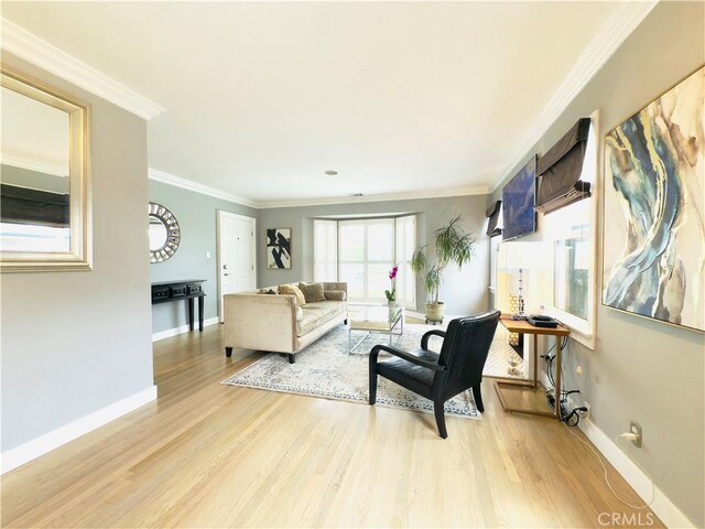 living area with light wood finished floors, baseboards, and crown molding