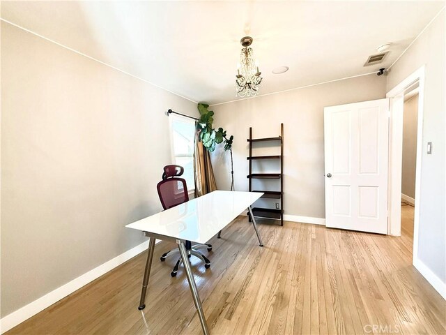 office area featuring a chandelier, baseboards, visible vents, and light wood finished floors