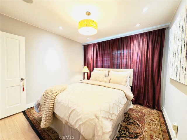 bedroom with recessed lighting, baseboards, and wood finished floors