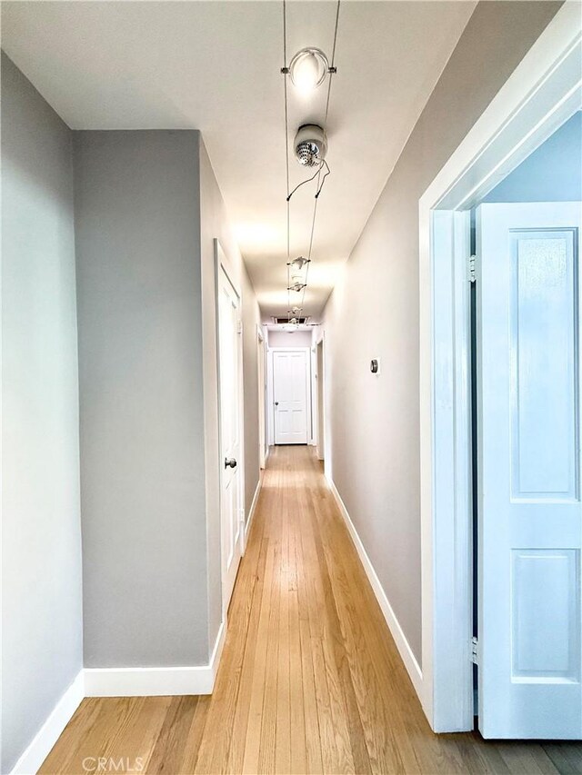 hallway with baseboards and light wood finished floors