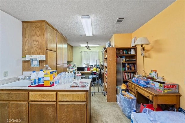 kitchen featuring visible vents, a ceiling fan, light colored carpet, open floor plan, and light countertops