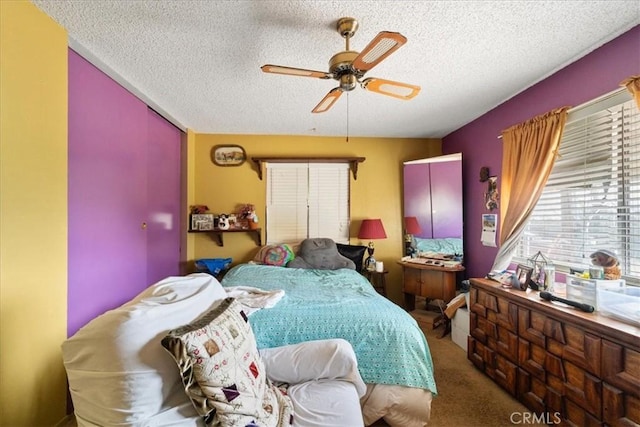 bedroom featuring a textured ceiling, ceiling fan, and carpet flooring