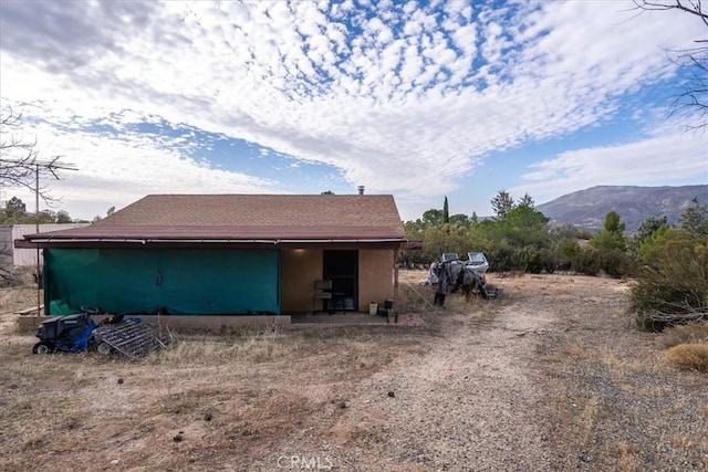 rear view of house featuring an outbuilding and a mountain view