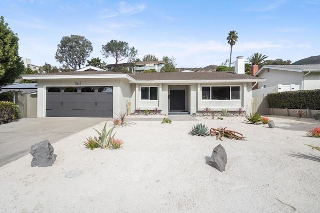 single story home with concrete driveway, fence, an attached garage, and stucco siding