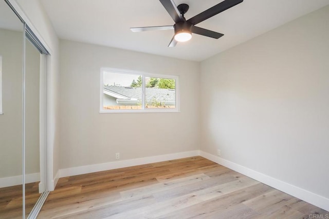 unfurnished bedroom featuring light wood-style floors, a ceiling fan, baseboards, and a closet