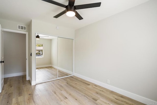 unfurnished bedroom with a ceiling fan, visible vents, baseboards, a closet, and light wood-type flooring