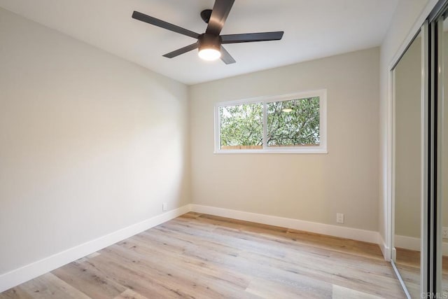 unfurnished bedroom featuring a ceiling fan, a closet, light wood-style flooring, and baseboards