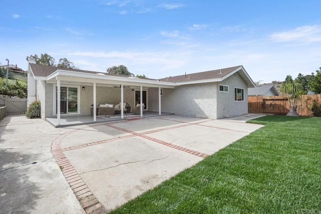 back of property with roof with shingles, a patio, stucco siding, a lawn, and fence