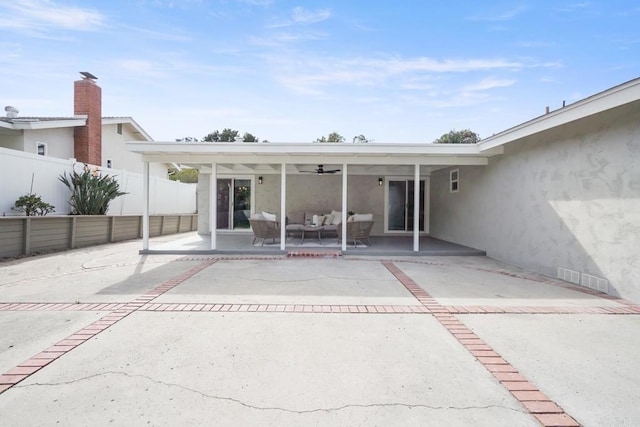 back of house featuring ceiling fan, fence, a patio area, an outdoor living space, and stucco siding