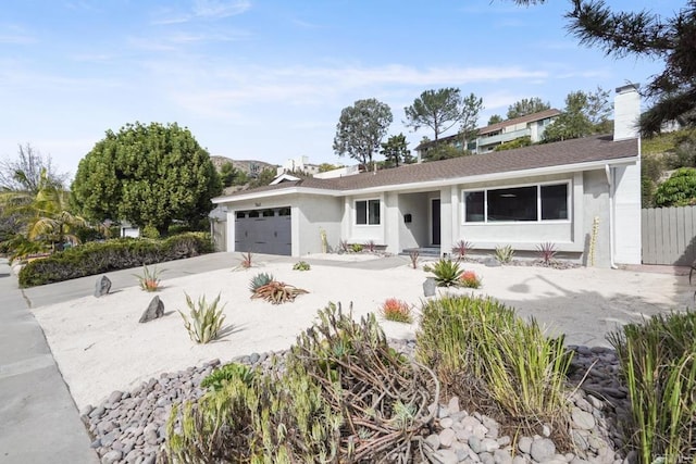 single story home with a garage, fence, concrete driveway, and stucco siding