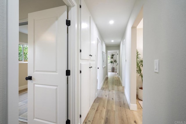 hall featuring recessed lighting, baseboards, and light wood finished floors