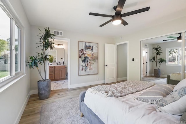 bedroom with light wood-type flooring, baseboards, visible vents, and a ceiling fan