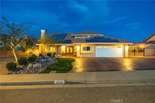 view of front of house featuring a garage, driveway, fence, and stucco siding