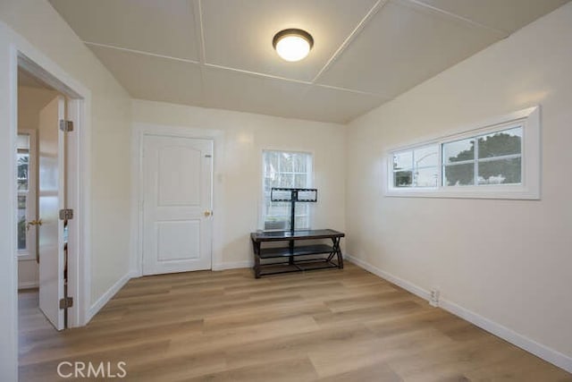 spare room with baseboards and light wood finished floors