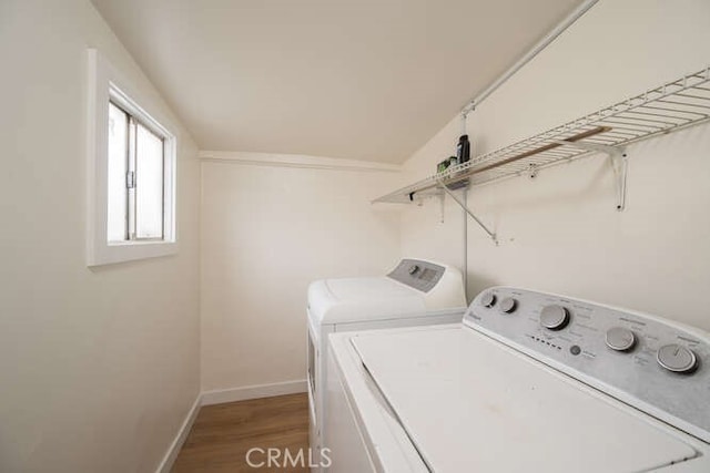 laundry room featuring washing machine and clothes dryer, laundry area, baseboards, and wood finished floors