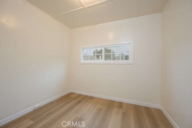 unfurnished room with baseboards and light wood-style flooring