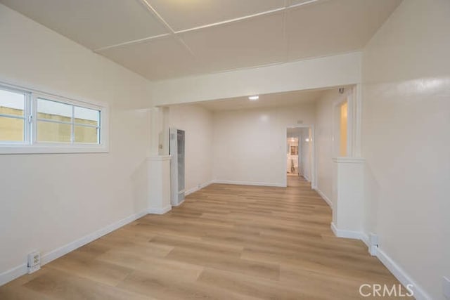 unfurnished room featuring baseboards and light wood finished floors