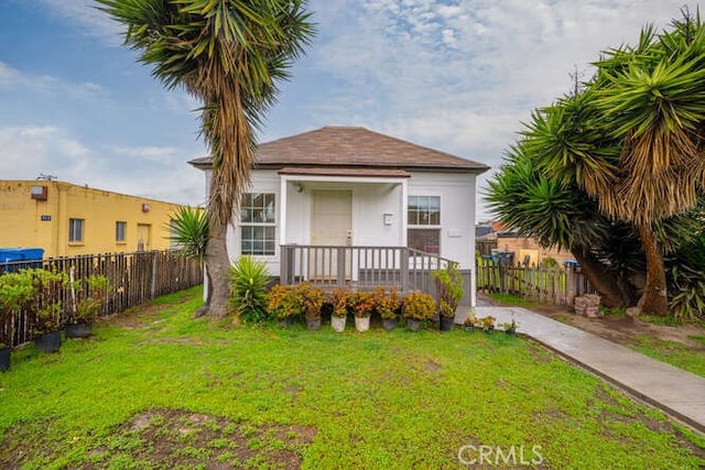 view of front of home featuring a front lawn, fence, and stucco siding