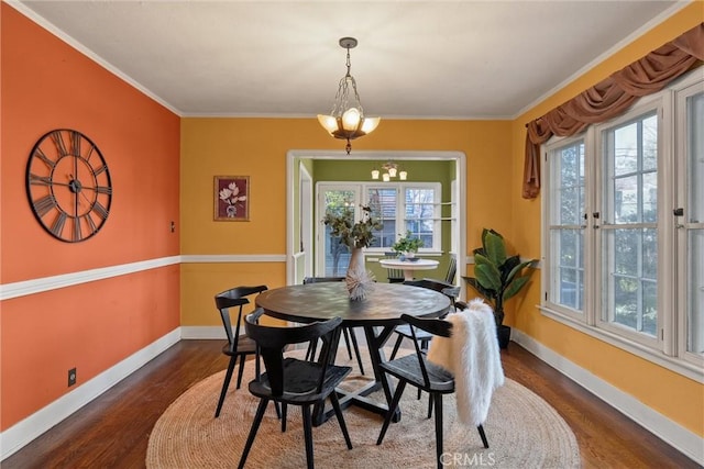 dining area featuring crown molding, dark wood-style flooring, plenty of natural light, and baseboards