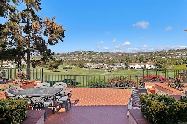 view of patio / terrace with golf course view, fence, and outdoor dining area