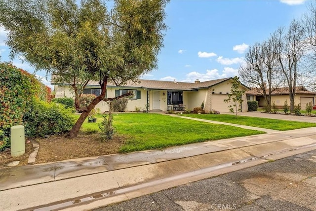 single story home with an attached garage, concrete driveway, brick siding, and a front yard