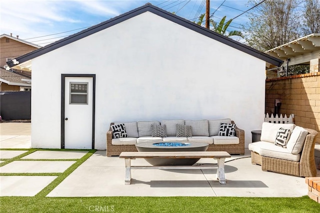 view of patio featuring an outdoor living space with a fire pit and fence