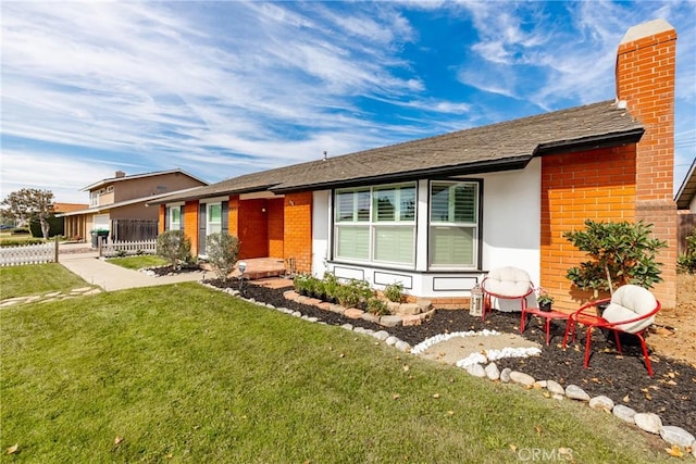 ranch-style home with brick siding, a front lawn, and a chimney