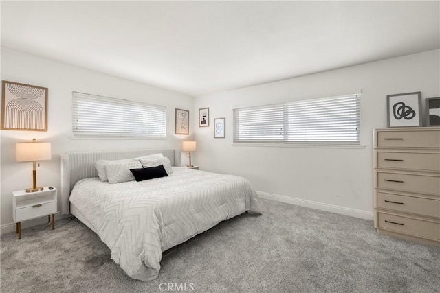 bedroom featuring carpet flooring, baseboards, and multiple windows