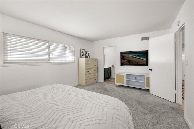 bedroom featuring light colored carpet, visible vents, connected bathroom, and baseboards