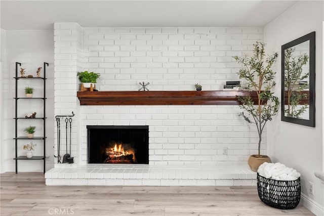 interior details featuring a fireplace, baseboards, and wood finished floors