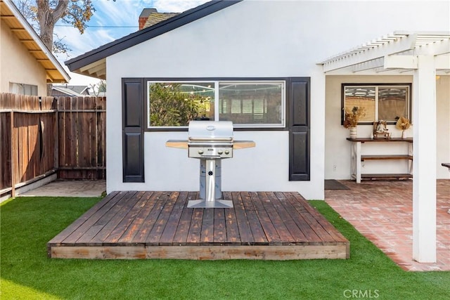 exterior space with area for grilling, fence, and a pergola