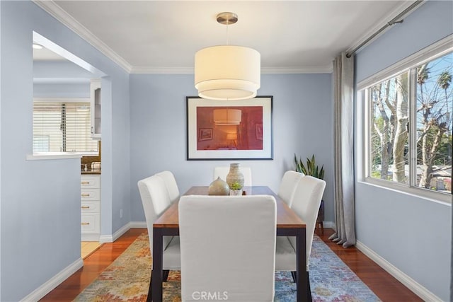 dining area featuring ornamental molding, wood finished floors, and baseboards