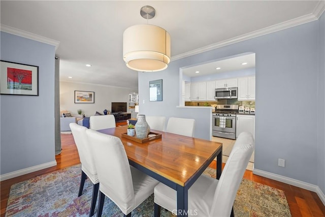 dining space featuring ornamental molding, light wood-style flooring, and baseboards