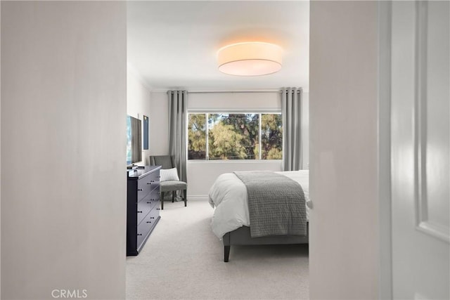 bedroom featuring light carpet and crown molding