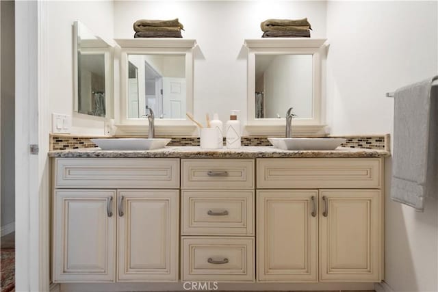 full bathroom with double vanity and a sink