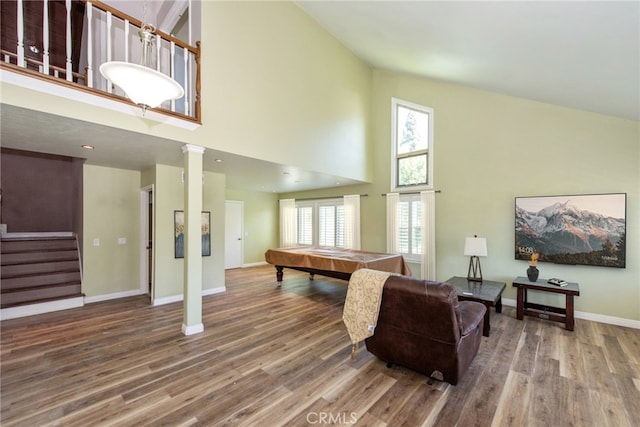 living area featuring a high ceiling, billiards, wood finished floors, baseboards, and stairs