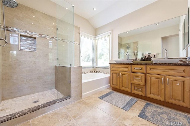 bathroom featuring double vanity, a garden tub, a shower stall, and a sink