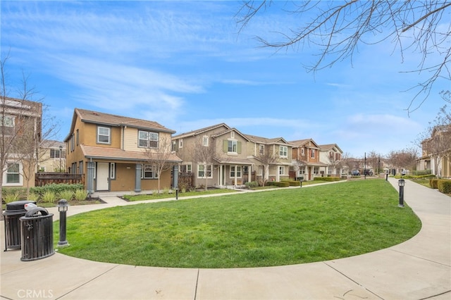 townhome / multi-family property with covered porch, a residential view, a front lawn, and stucco siding