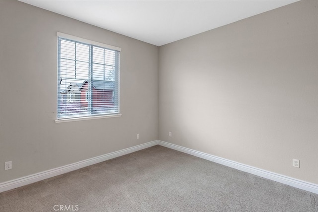 carpeted spare room with baseboards