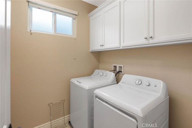 clothes washing area with independent washer and dryer and cabinet space