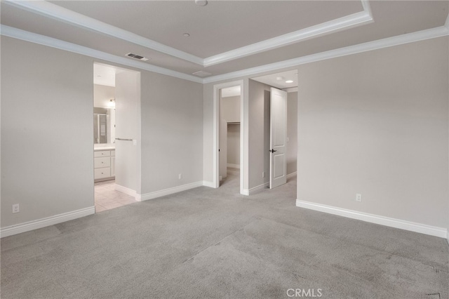 unfurnished bedroom with light carpet, visible vents, a raised ceiling, and ornamental molding