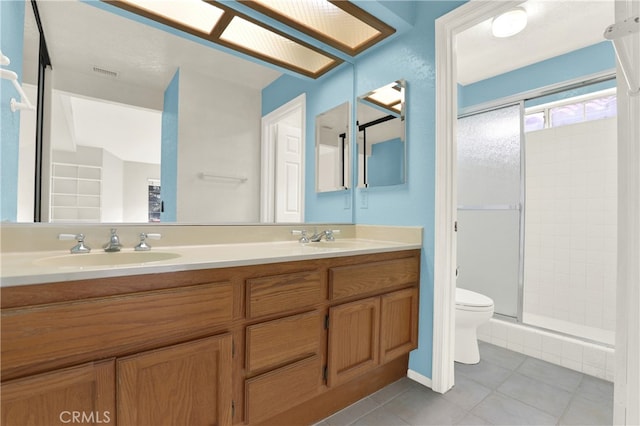 full bath with tile patterned flooring, a shower stall, toilet, a sink, and visible vents