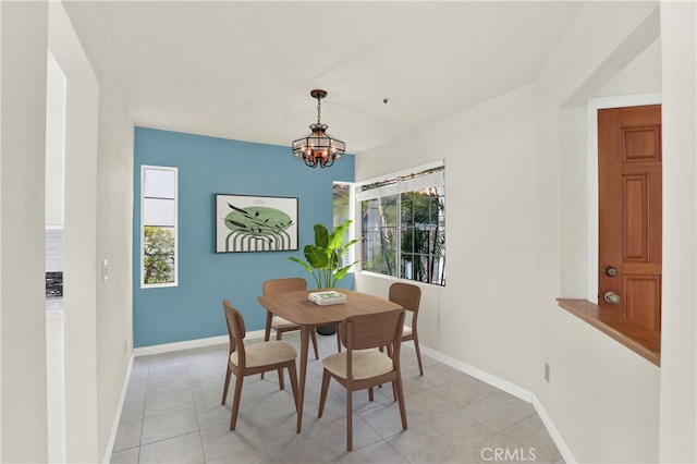 dining room featuring light tile patterned flooring, a chandelier, and baseboards