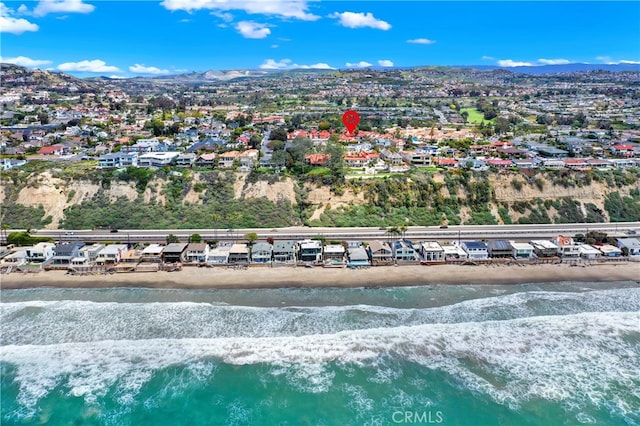 drone / aerial view featuring a beach view, a water and mountain view, and a residential view