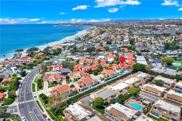 drone / aerial view with a view of the beach, a water view, and a residential view