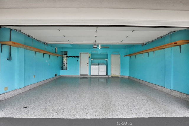 garage featuring baseboards, a garage door opener, and washer and dryer