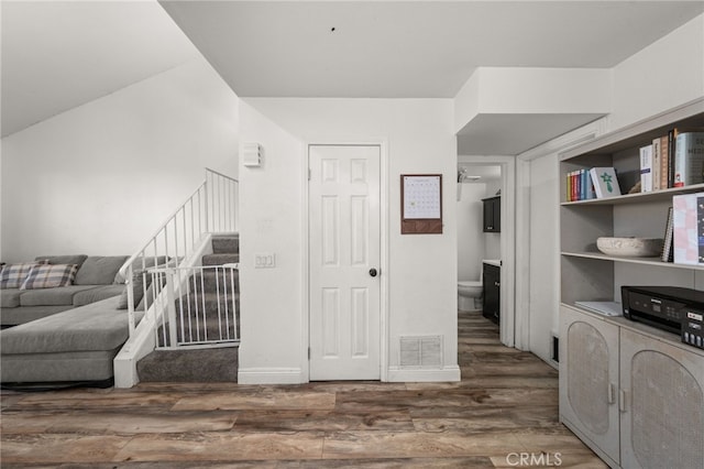 interior space with stairway, wood finished floors, visible vents, and baseboards